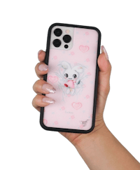 a woman holding a pink phone case with a teddy bear on it